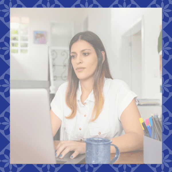 Latina leadership coaching program member uses her laptop to access educational courses.